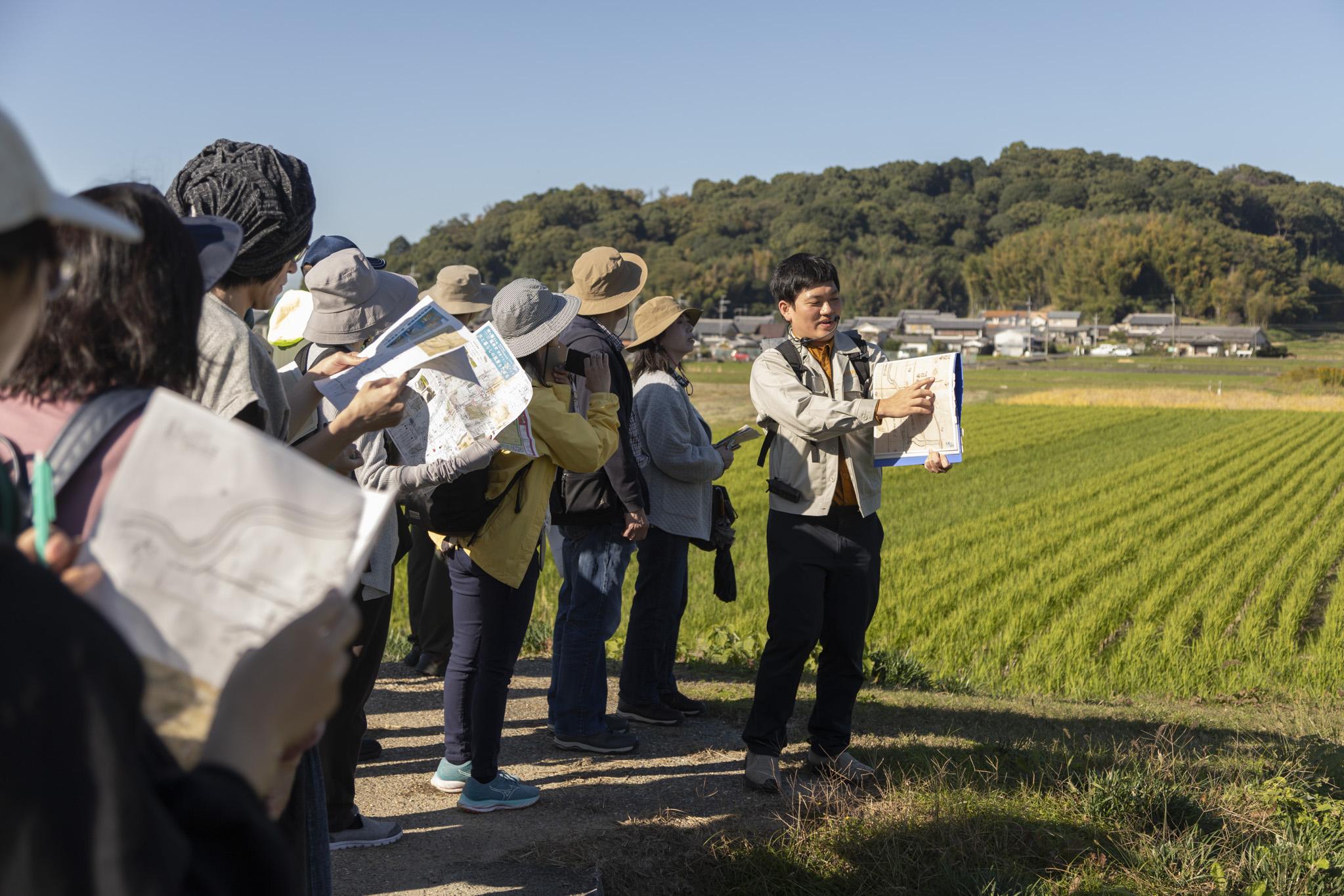 研究員が屋外で解説する画像