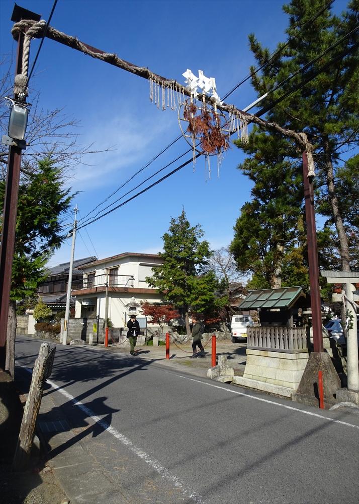 道路に鳥居のようにまたいで掛けられるかんじょうなわの写真