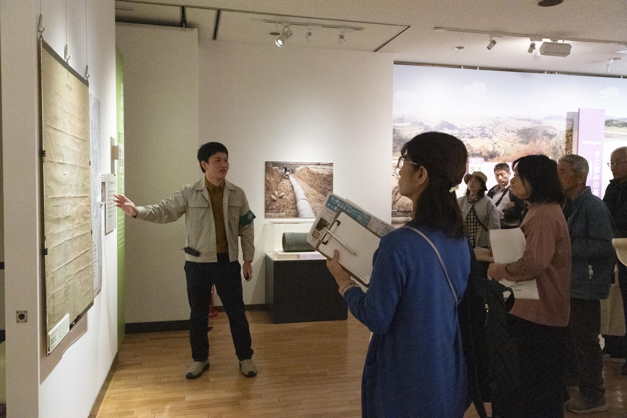研究員が展示解説をする画像