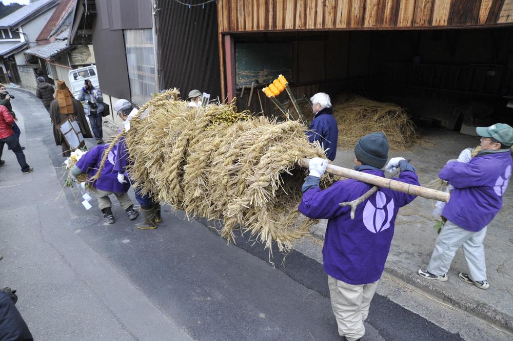 龍福寺住職の先導で作業場から運び出されるめづなの写真