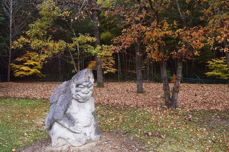 庭園の猿石と落ち葉の写真