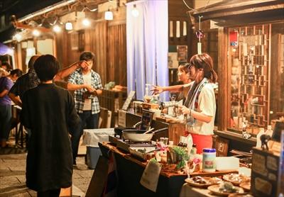 明日香村の夜のイベントで町屋の前で販売している女性がお客さんと楽しそうに会話している写真