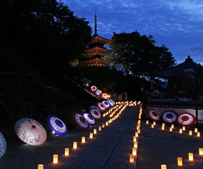 岡寺の参道にそってろうそくがともされ和傘が配置された夕刻のの写真