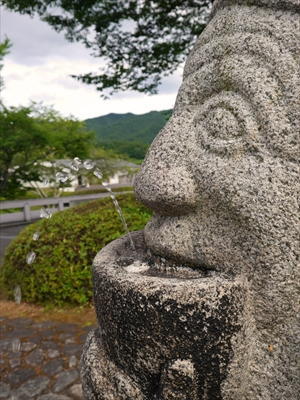 石人ぞうの口元から水が出ている写真