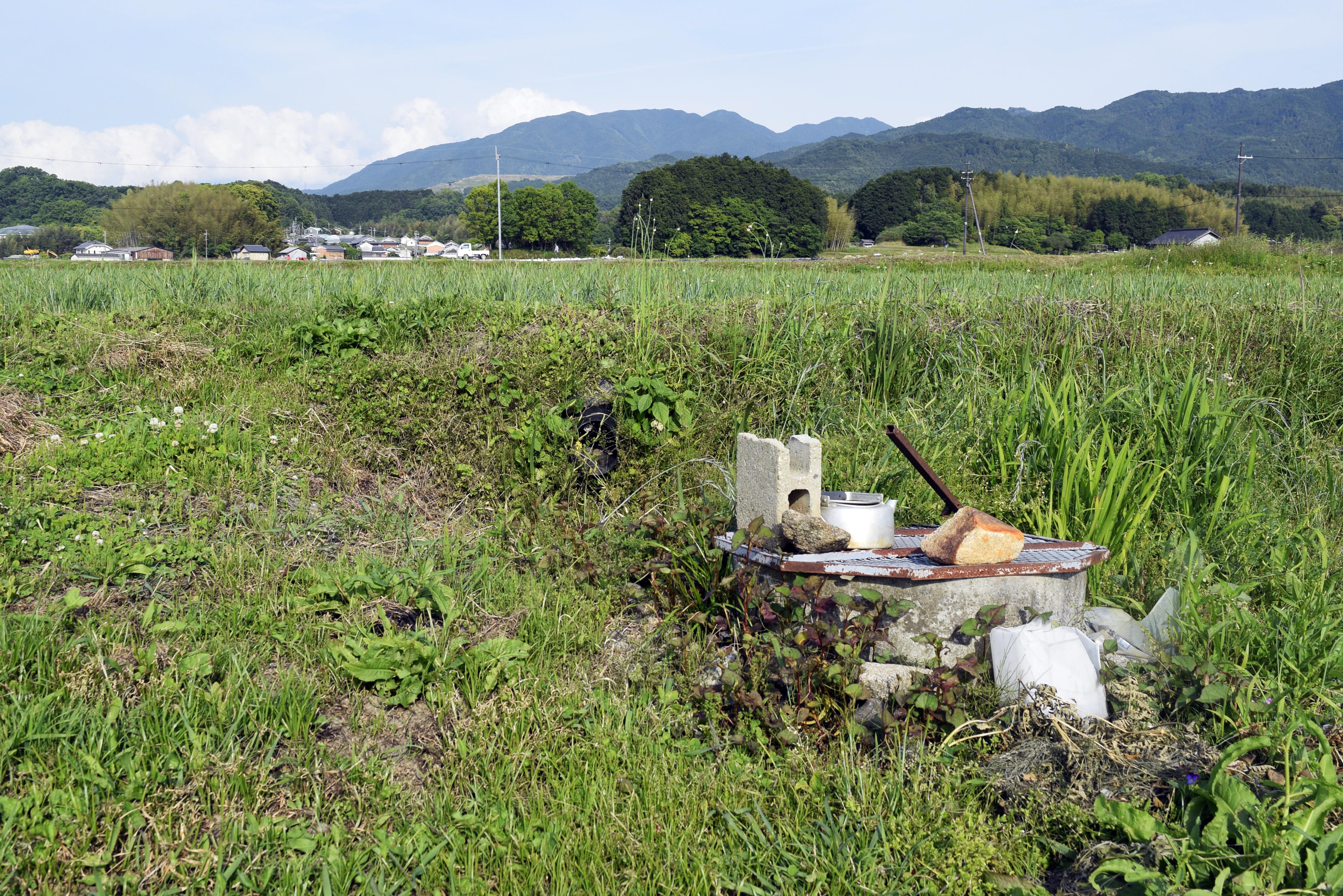 蓋の上に石やブロックを置かれている古井戸