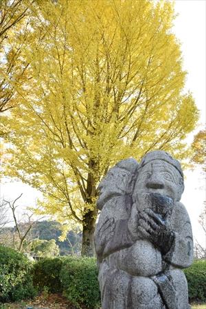 紅葉したイチョウと庭園の石人像の写真