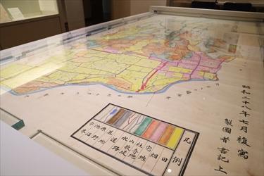 展示台一面に広げられた地籍図の写真